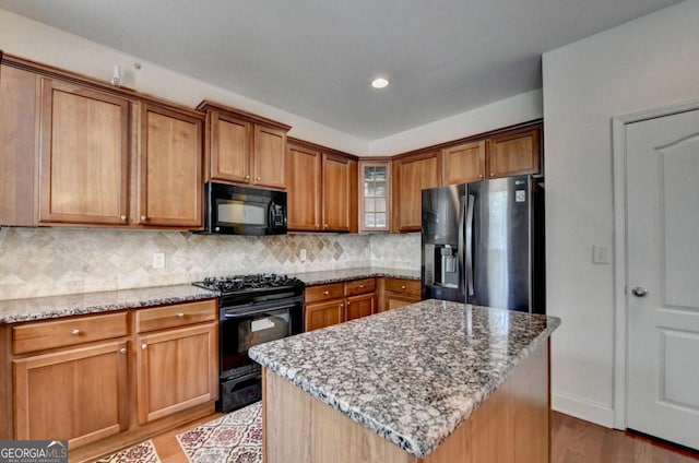 25 Kaktovic Ct, Grayson, GA 30017 - kitchen with black appliances, light wood-type flooring, light stone counters, and recessed lighting