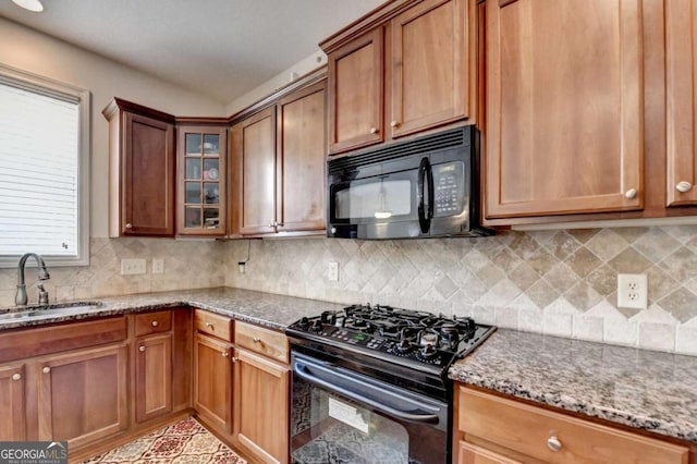25 Kaktovic Ct, Grayson, GA 30017 - kitchen with black appliances, a sink, stone countertops, glass insert cabinets, and brown cabinetry