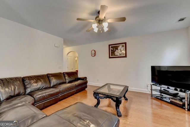 25 Kaktovic Ct, Grayson, GA 30017 - living room featuring arched walkways, a ceiling fan, wood finished floors, and baseboards