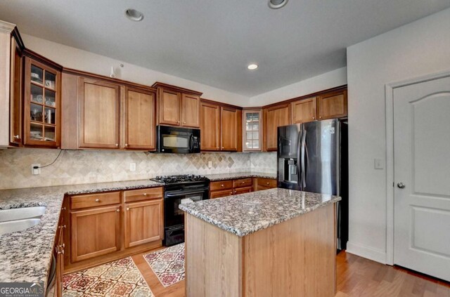 25 Kaktovic Ct, Grayson, GA 30017 - kitchen featuring black appliances, light wood-style flooring, light stone counters, a center island, and recessed lighting