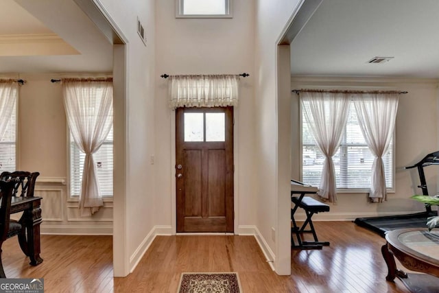 25 Kaktovic Ct, Grayson, GA 30017 - foyer entrance with light wood finished floors, ornamental molding, and a wainscoted wall