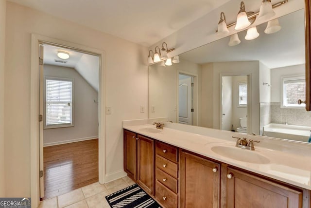 25 Kaktovic Ct, Grayson, GA 30017 - full bathroom featuring toilet, healthy amount of natural light, double vanity, and tile patterned floors
