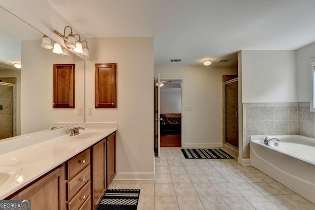 25 Kaktovic Ct, Grayson, GA 30017 - ensuite bathroom featuring tile patterned flooring, a shower stall, double vanity, a garden tub, and baseboards