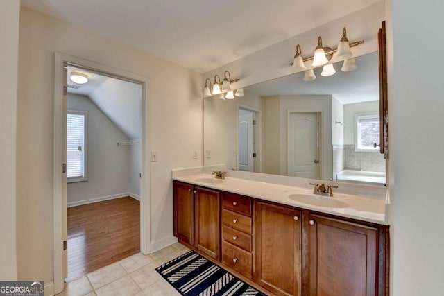 25 Kaktovic Ct, Grayson, GA 30017 - full bathroom featuring double vanity, tile patterned flooring, vaulted ceiling, and baseboards