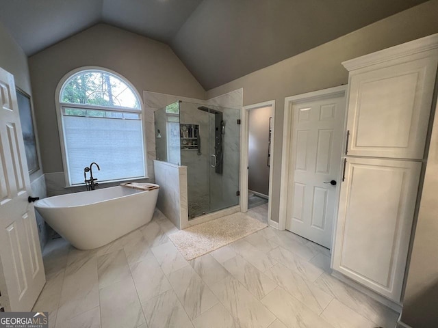 1122 Montclair Dr, Peachtree City, GA 30269 - bathroom featuring a stall shower, a freestanding tub, lofted ceiling, and marble look tile flooring