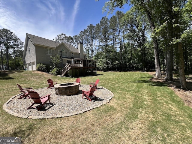 1122 Montclair Dr, Peachtree City, GA 30269 - view of grassy yard with an outdoor fire pit, a deck, an attached garage, and stairs