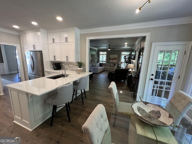 1122 Montclair Dr, Peachtree City, GA 30269 - kitchen with freestanding refrigerator, a sink, crown molding, white cabinetry, and light countertops