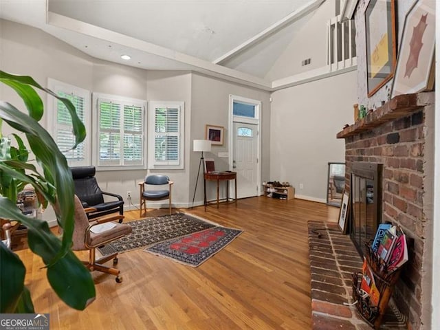 760 Ashland Ave, Atlanta, GA 30307 - living room featuring wood finished floors, vaulted ceiling, baseboards, a fireplace, and recessed lighting