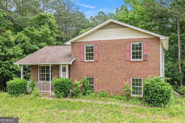1576 King Mill Rd, Mcdonough, GA 30252 - view of front facade featuring brick siding, roof with shingles, a front lawn, and view of scattered trees