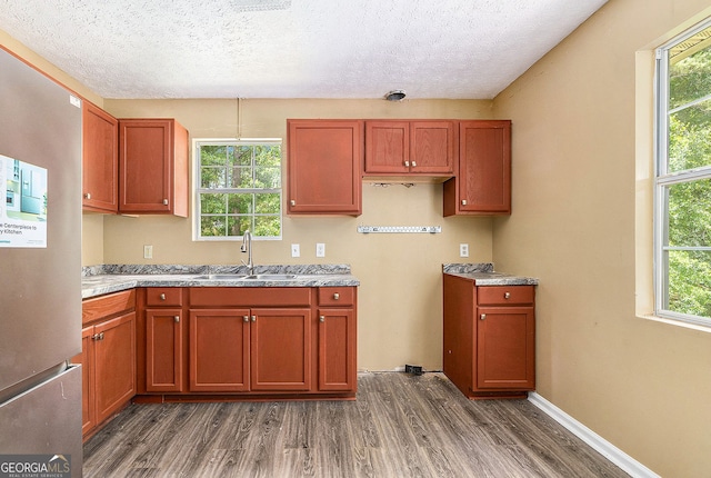 1576 King Mill Rd, Mcdonough, GA 30252 - kitchen with freestanding refrigerator, wood finished floors, a textured ceiling, healthy amount of natural light, and light stone countertops