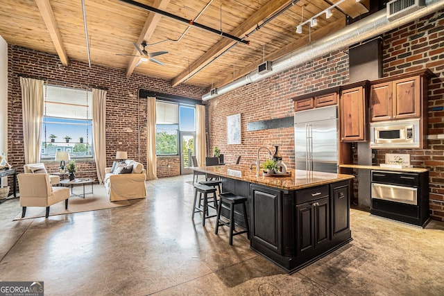 204 Walker St SW Unit 319, Atlanta, GA 30313 - kitchen featuring brick wall, built in appliances, wooden ceiling, concrete floors, and a high ceiling