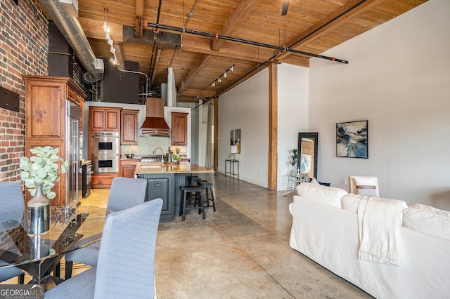 204 Walker St SW Unit 319, Atlanta, GA 30313 - kitchen featuring stainless steel appliances, custom exhaust hood, a high ceiling, open floor plan, and light countertops