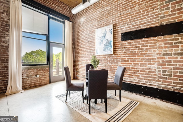 204 Walker St SW Unit 319, Atlanta, GA 30313 - dining space featuring brick wall, concrete flooring, and a high ceiling