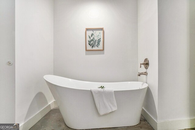 204 Walker St SW Unit 319, Atlanta, GA 30313 - bathroom with baseboards, a freestanding tub, and concrete flooring