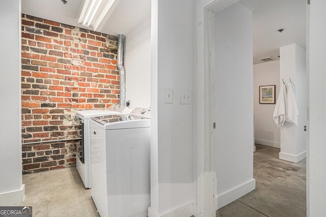 204 Walker St SW Unit 319, Atlanta, GA 30313 - clothes washing area with washing machine and clothes dryer, brick wall, and baseboards