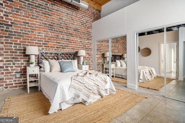 204 Walker St SW Unit 319, Atlanta, GA 30313 - bedroom with multiple closets, a high ceiling, concrete floors, and brick wall