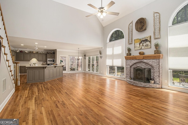 3780 Lovers Ln, Monroe, GA 30656 - unfurnished living room with ceiling fan, high vaulted ceiling, light wood finished floors, a fireplace, and baseboards