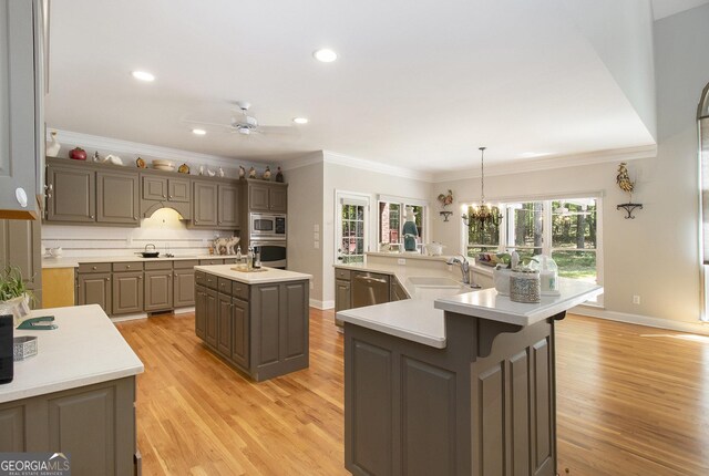 3780 Lovers Ln, Monroe, GA 30656 - kitchen with a spacious island, appliances with stainless steel finishes, a sink, light wood-style floors, and light countertops