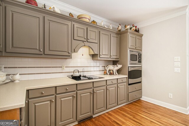 3780 Lovers Ln, Monroe, GA 30656 - kitchen with appliances with stainless steel finishes, gray cabinets, tasteful backsplash, light countertops, and crown molding