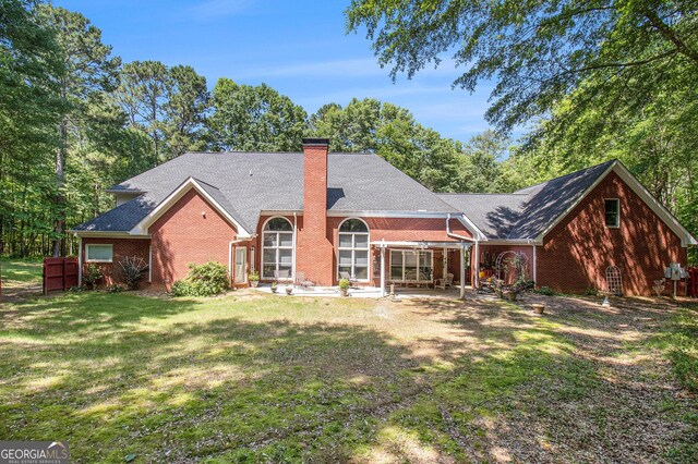 3780 Lovers Ln, Monroe, GA 30656 - rear view of house featuring brick siding, a chimney, and a yard
