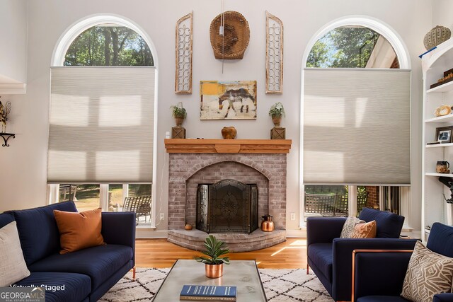 3780 Lovers Ln, Monroe, GA 30656 - living room featuring a brick fireplace, plenty of natural light, wood finished floors, and built in shelves