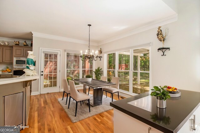 3780 Lovers Ln, Monroe, GA 30656 - dining room with crown molding, light wood-style flooring, and a chandelier
