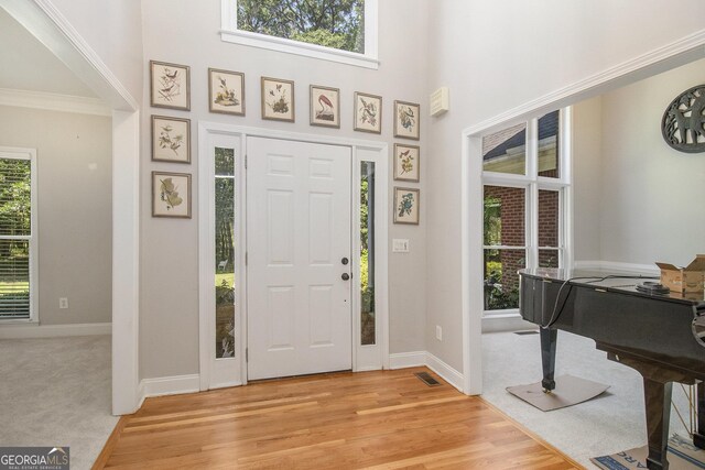 3780 Lovers Ln, Monroe, GA 30656 - foyer entrance with baseboards, a high ceiling, light wood-style floors, and ornamental molding