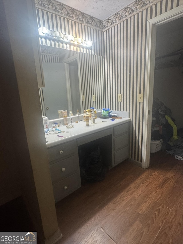 411 Willow Ct SE, Conyers, GA 30094 - bathroom with wallpapered walls, wood finished floors, and vanity