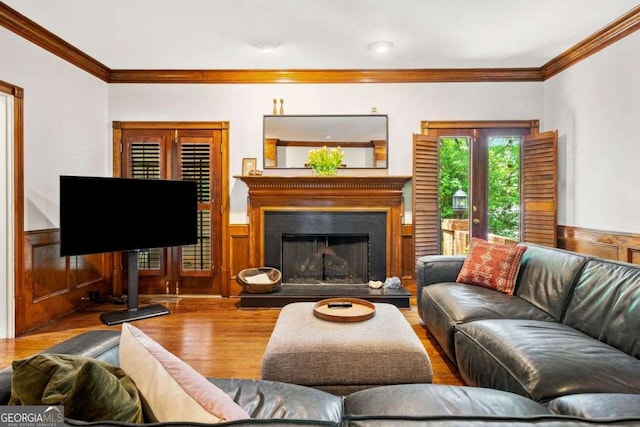 4411 Paces Battle NW, Atlanta, GA 30327 - living room featuring wood finished floors, ornamental molding, a fireplace with raised hearth, and a wainscoted wall