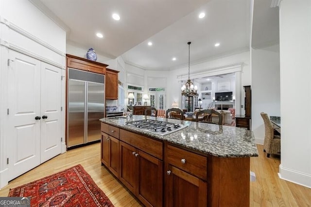 4470 Crestwicke Pointe, Atlanta, GA 30319 - kitchen featuring stainless steel appliances, light wood-type flooring, dark stone counters, a center island, and recessed lighting