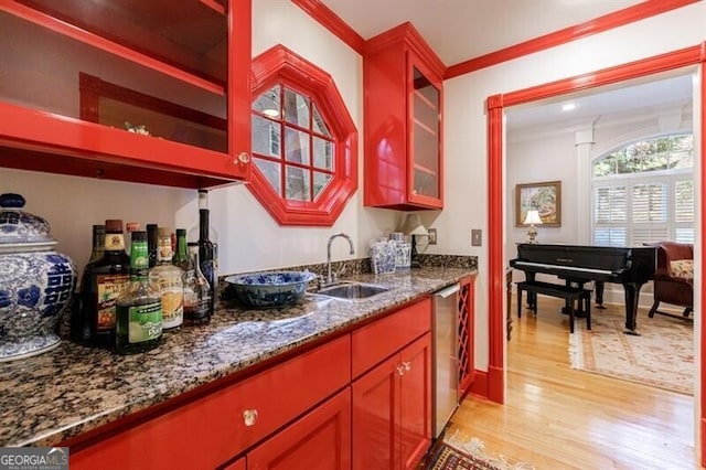 4470 Crestwicke Pointe, Atlanta, GA 30319 - kitchen featuring a sink, light wood-style floors, crown molding, dark stone countertops, and glass insert cabinets