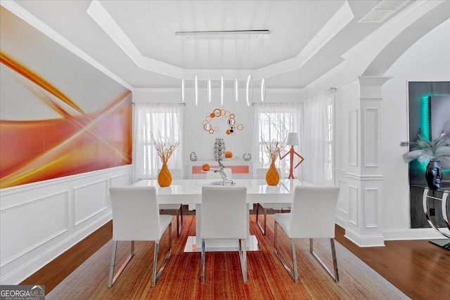 138 Lakestone Pkwy, Woodstock, GA 30188 - dining space with ornate columns, wood finished floors, arched walkways, and a raised ceiling