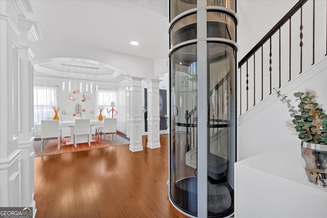 138 Lakestone Pkwy, Woodstock, GA 30188 - entrance foyer with decorative columns, arched walkways, wood finished floors, a tray ceiling, and stairway
