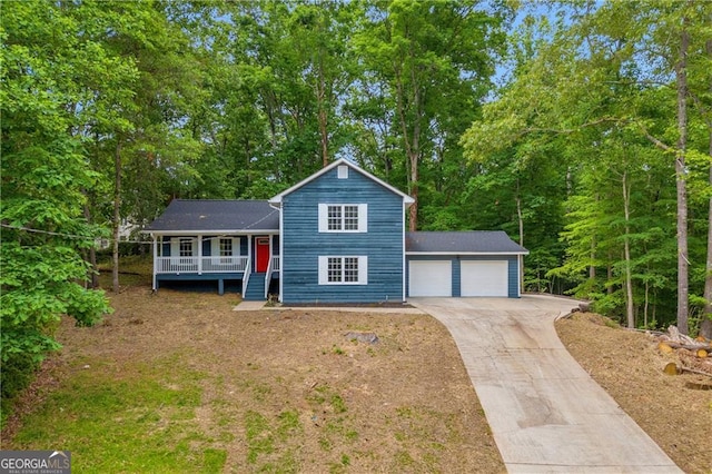 view of front of home featuring a porch, concrete driveway, and a garage