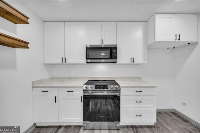 5200 Beechwood Forest Ct, Lithonia, GA 30038 - kitchen featuring appliances with stainless steel finishes, light stone countertops, wood finished floors, and white cabinetry
