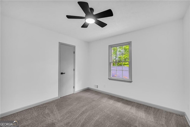 empty room with light colored carpet, ceiling fan, and baseboards
