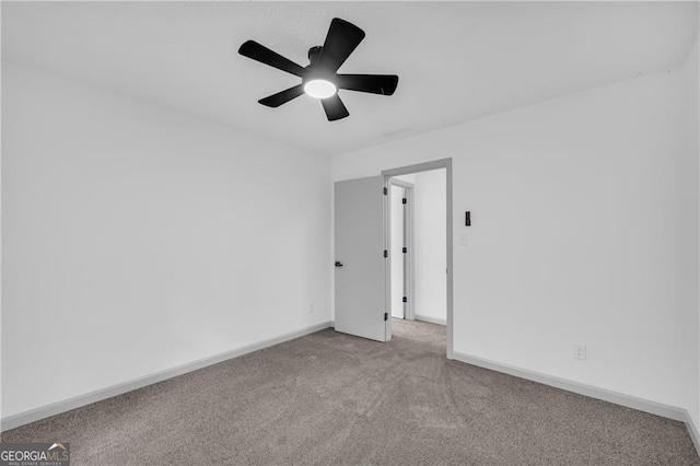 spare room with carpet flooring, baseboards, and ceiling fan