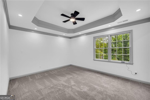 carpeted spare room with ornamental molding, a tray ceiling, ceiling fan, baseboards, and recessed lighting