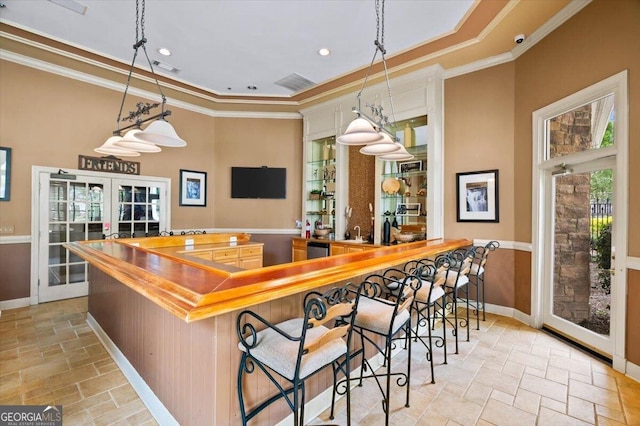 kitchen featuring french doors, ornamental molding, baseboards, stone tile flooring, and dishwasher