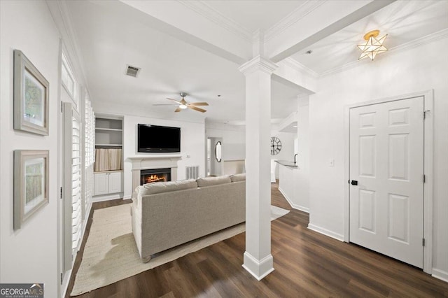 unfurnished living room featuring ceiling fan, dark wood-style flooring, a lit fireplace, ornamental molding, and baseboards