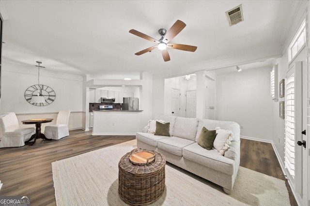 living area featuring a ceiling fan, ornamental molding, dark wood-style flooring, and baseboards