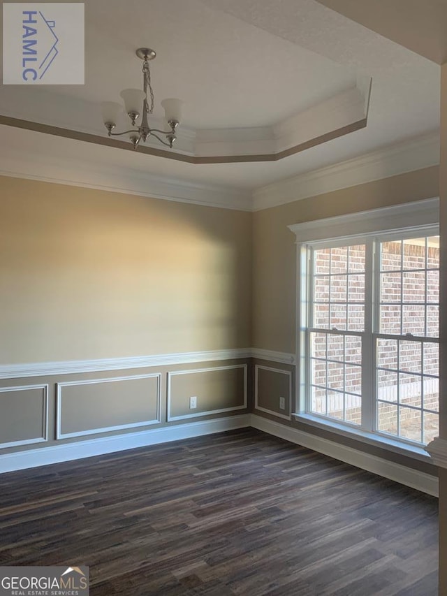 103 Abbie Ln, Glennville, GA 30427 - empty room with a chandelier, dark wood finished floors, a raised ceiling, crown molding, and wainscoting