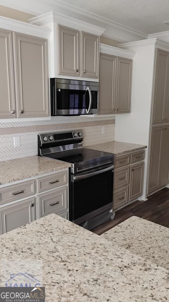 103 Abbie Ln, Glennville, GA 30427 - kitchen with stainless steel appliances, decorative backsplash, dark wood-style floors, crown molding, and light stone counters
