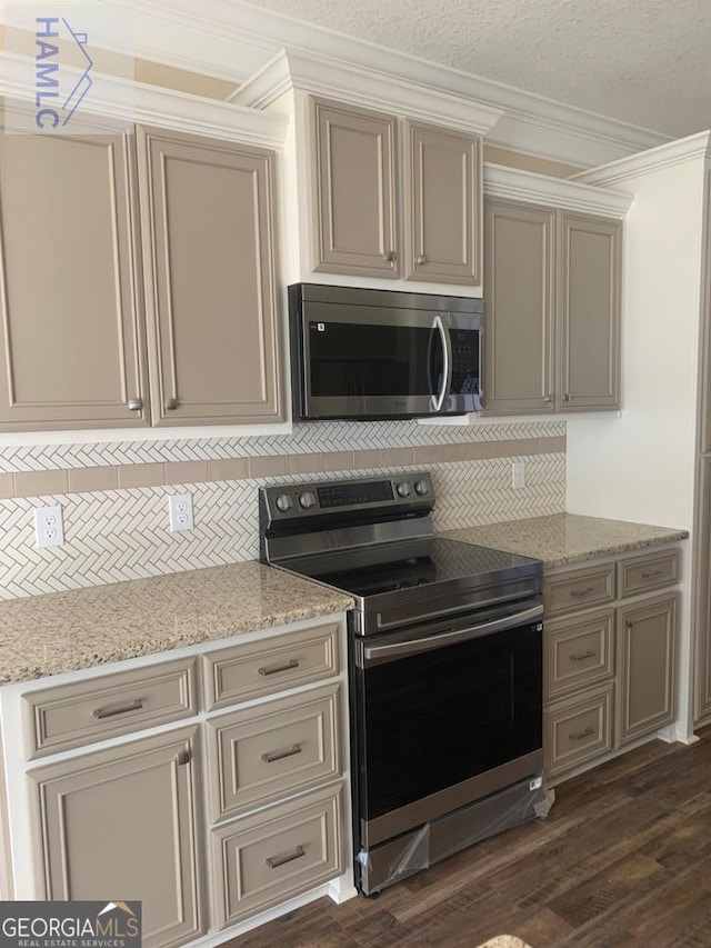 103 Abbie Ln, Glennville, GA 30427 - kitchen with stainless steel appliances, cream cabinets, decorative backsplash, ornamental molding, and dark wood-style floors