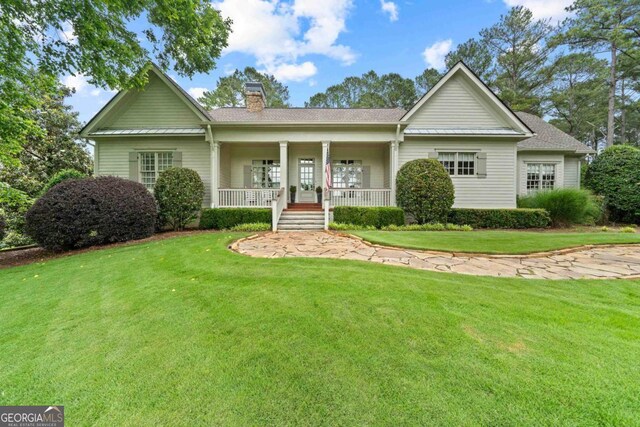 143 Wildwood Dr, Eatonton, GA 31024 - view of front of property with a chimney, covered porch, and a front lawn