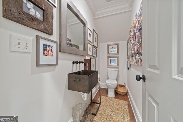 143 Wildwood Dr, Eatonton, GA 31024 - bathroom featuring crown molding, wood finished floors, toilet, and baseboards
