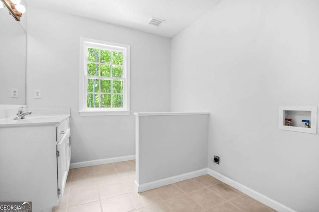 washroom featuring hookup for a washing machine, cabinet space, electric dryer hookup, light tile patterned floors, and baseboards