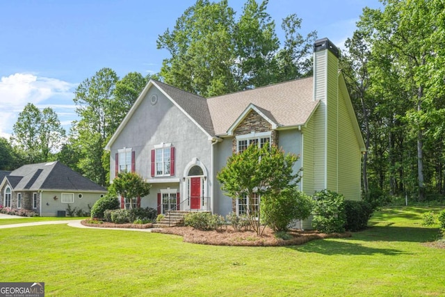 view of front facade featuring a front lawn, a chimney, and stucco siding