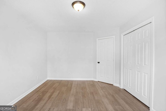 additional living space featuring wood finished floors and baseboards