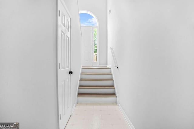 stairway with tile patterned floors and baseboards